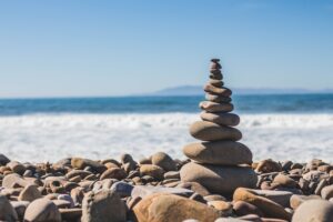 Stack of rocks in front of the beach. Living your best life in your 30's.