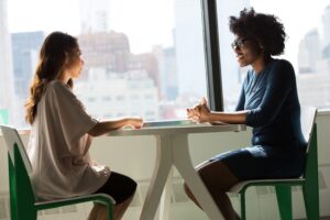 Two ladies at a cafe talking. The importance of boundaries for self-care. 