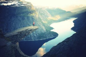 Person on the end of a cliff, doing a yoga pose.