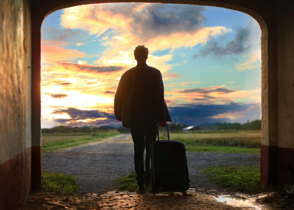 Person's shadow with a suitcase outside.