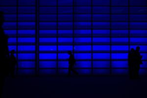 Blue hall with people walking and connecting.