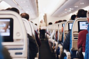 Aisle on plane with passengers.